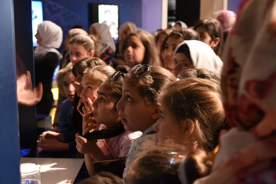 Children watching an exhibition display with interest.